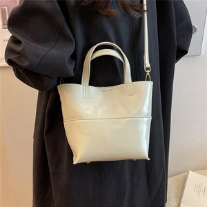 Dettaglio della borsa tote crema con hardware in metallo dorato e cuciture raffinate