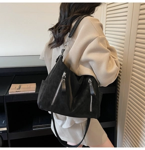 Vue détaillée du grand sac bandoulière noir mat avec fermetures éclair argentées et sangle