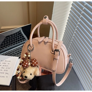 Pink minimalist bowling bag detail with cute puppy plush charm and smooth leather texture