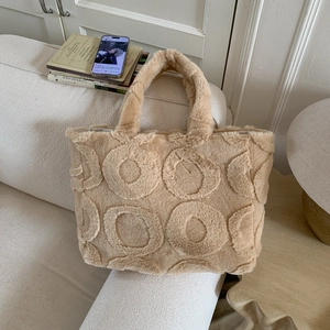 Macro detail of camel plush tote bag featuring unique embossed circular texture