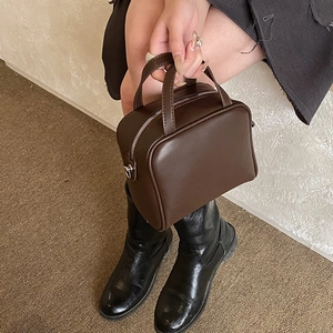 Top-down view of a vintage dark brown leather handbag with double handles and metal zipper