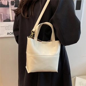 Borsa tote versatile in ecopelle crema indossata con tracolla regolabile e manici