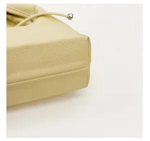 Detail of the cream hobo bag showing reinforced bottom and precision stitching for durability