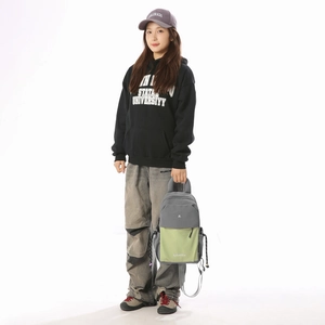 Lifestyle shot of lightweight green and grey multi-color backpack worn by a female model