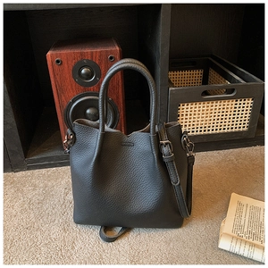 Close-up of black lychee grain leather bucket bag showing texture and silver hardware detail