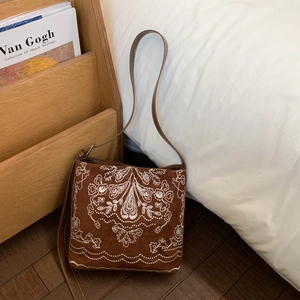 Gros plan détaillé d'un sac à bandoulière vintage marron avec broderie blanche raffinée