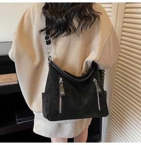 Détail d'un grand sac fourre-tout noir en daim avec doubles fermetures éclair argentées