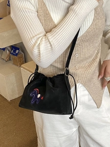 Black drawstring bucket bag with pony embroidery and sleek adjustable shoulder strap