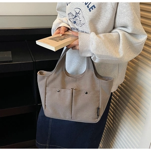 Detail of grey-brown minimalist tote bag with dual front pockets and silver metal snaps