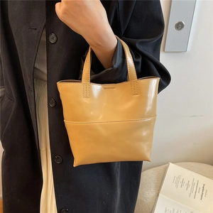 Dettaglio della borsa tote in pelle giallo senape con eleganti cuciture orizzontali
