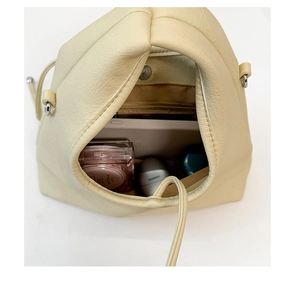 Top view detail of creamy faux leather dumpling bag showing spacious interior storage