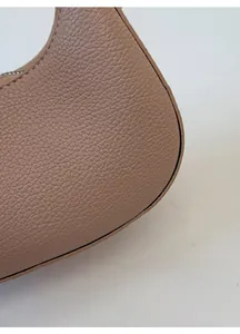 Détail de la texture grainée et des coutures fines sur le sac en cuir couleur kaki