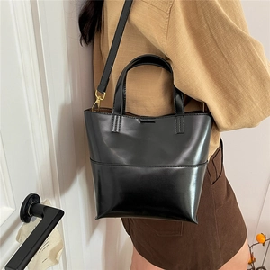 Dettaglio borsa tote in ecopelle nera con finiture dorate e tracolla rimovibile inclusa