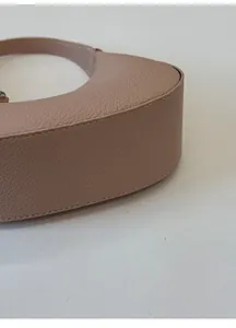 Détail du fond large d'un sac à bandoulière en cuir avec motif litchi de style épuré
