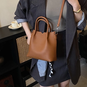 Brown litchi grain leather tote bag with V-cut edge and shoulder strap detail