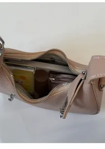 Vue intérieure du sac à bandoulière en cuir montrant la capacité pour téléphone et maquillage