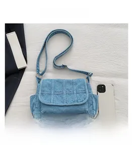 Detail view of light blue denim crossbody bag with multi-pockets and adjustable strap