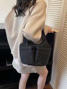 Minimalist black puffer nylon bucket bag with quilted design and large capacity handle