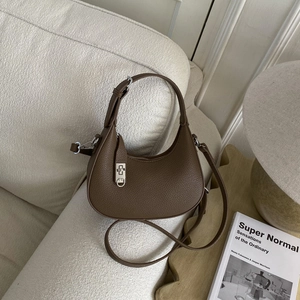 Détail du sac hobo marron foncé avec texture grainée et fermoir rotatif argenté