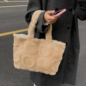 Close-up of beige plush tote bag with embossed circular patterns and soft faux fur texture