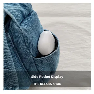 Detail view of the side pocket on denim shoulder bag holding wireless earbuds case
