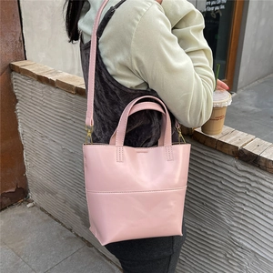 Borsa tote in pelle rosa con cuciture fini e tracolla rimovibile in un contesto urbano