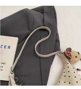 Detail of cream polka dot shoulder bag with cute bear charm and heart pendant