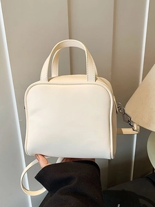 Minimalist cream white crossbody bag with dual handles and adjustable shoulder strap