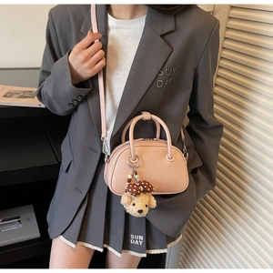 Detailed shot of pink PU leather bowling bag with brown polka dot bear charm