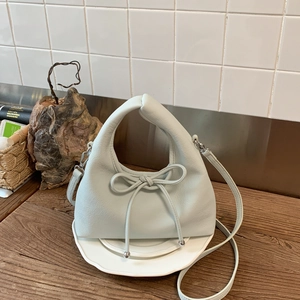 Detailed macro view of the light green lychee leather and stylish bow on the handbag