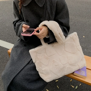 Detail showing off-white plush tote bag with geometric diamond texture and thick fur handle