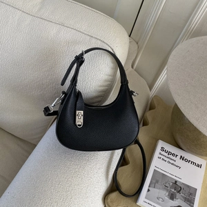 Vue détaillée d'un sac hobo noir à texture lychee avec fermoir rotatif argenté élégant
