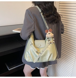 Green vintage shoulder bag featuring glossy pleated leather and a cute plush bear charm