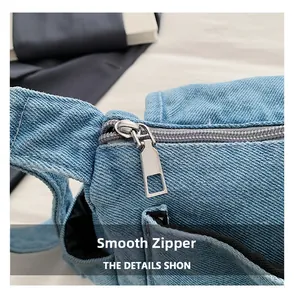 Close-up of smooth silver metal zipper and durable denim texture on the shoulder bag
