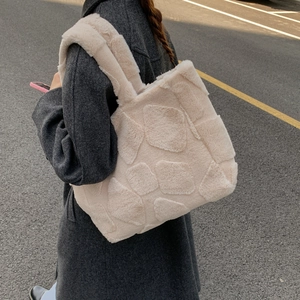 Outdoor shot showing the plush texture and square geometric pattern of this cream tote bag
