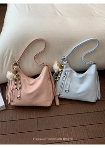 Detail of pink and light blue retro hobo bags with decorative plush ball charms