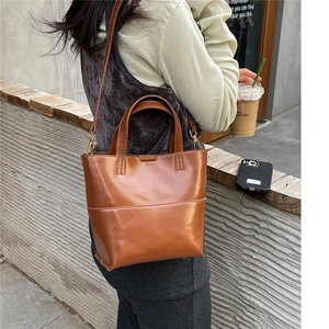 Borsa tote marrone in ecopelle mostrata in un ambiente casual urbano all'aperto