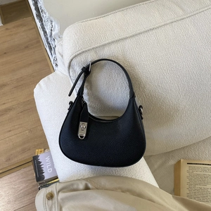 Gros plan sur le sac croissant en cuir noir grainé avec boucle rotative carrée argentée