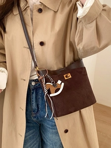 Deep brown matte bucket bag with a metal twist lock and a cute horse bag charm