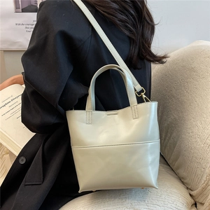 Primo piano della borsa tote verde chiaro con tracolla regolabile indossata da una modella