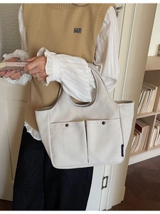 Minimalist cream canvas tote bag with front snap pockets for stylish daily commuting