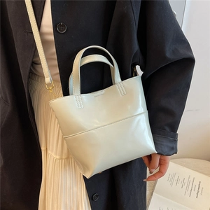 Borsa tote in pelle PU verde chiaro lucida con tracolla indossata da una modella