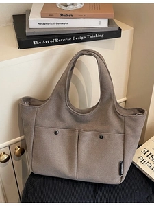 Minimalist tan canvas tote bag with front pockets and retro buttons for commute