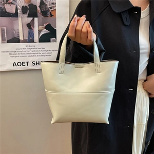 Dettaglio borsa tote bianco crema con cucitura orizzontale e manici rinforzati stabili
