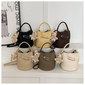 Detailed arrangement of six bucket bags in neutral colors with cute teddy bear charms