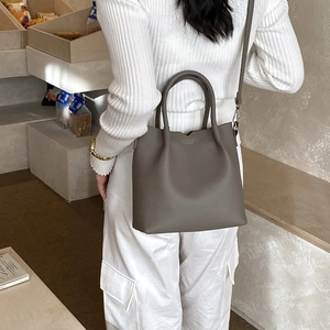 Detail shot of taupe pebbled leather tote bag showing v-cut neckline and soft texture