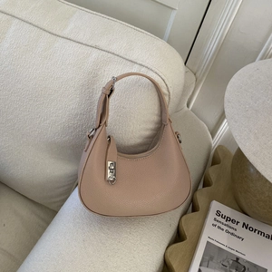 Gros plan détaillé du cuir grainé beige et de la boucle argentée sur le sac hobo chic