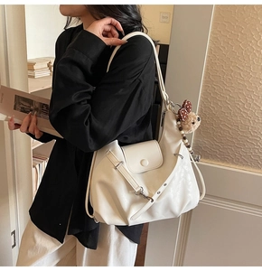 Detail of white PU leather cloud-style handbag with bear pendant and beaded accessories