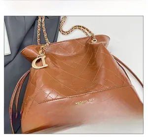 Détail du sac seau matelassé beige avec texture cuir et breloque dorée élégante