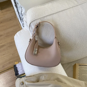 Détail de la texture en cuir beige et des garnitures argentées sur un sac porté épaule hobo